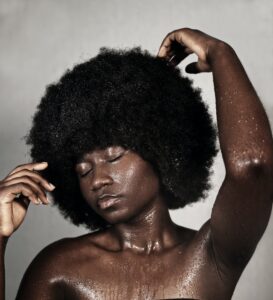 Black woman touching wet afro