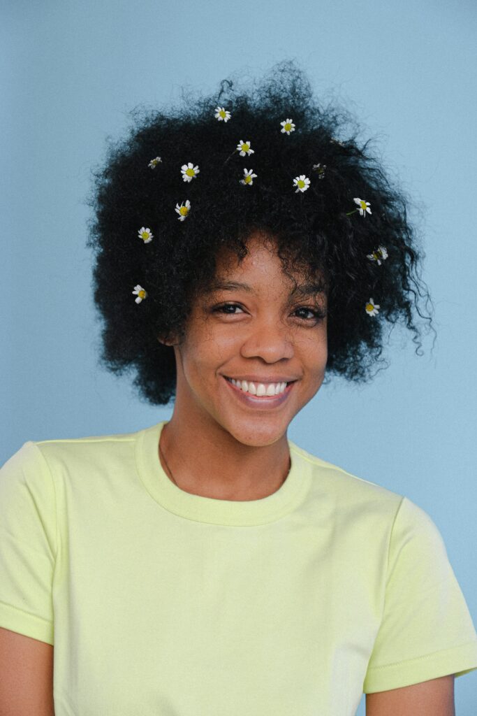 4b head shot, type 4 hair, woman with daisy flowers in hair